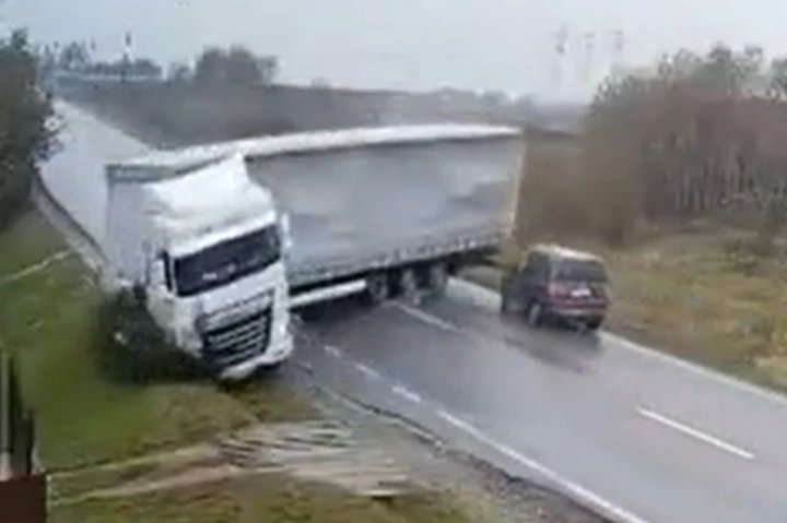 Horrifying moment skidding jackknifed lorry flattens car killing two after losing control on rain-soaked road